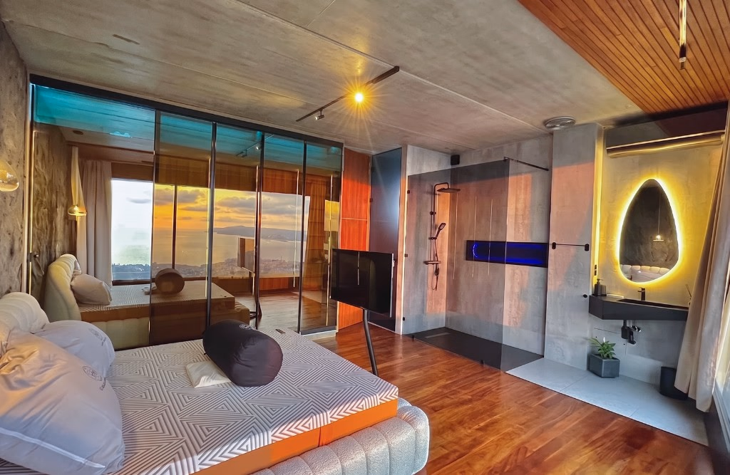 Suite parentale avec vue mer panoramique, salle de bain ouverte et finitions bois — Villa de luxe Tanger Nouinouich